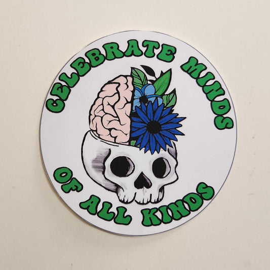 Circular sticker with skull, brain, and flower design on a plain background