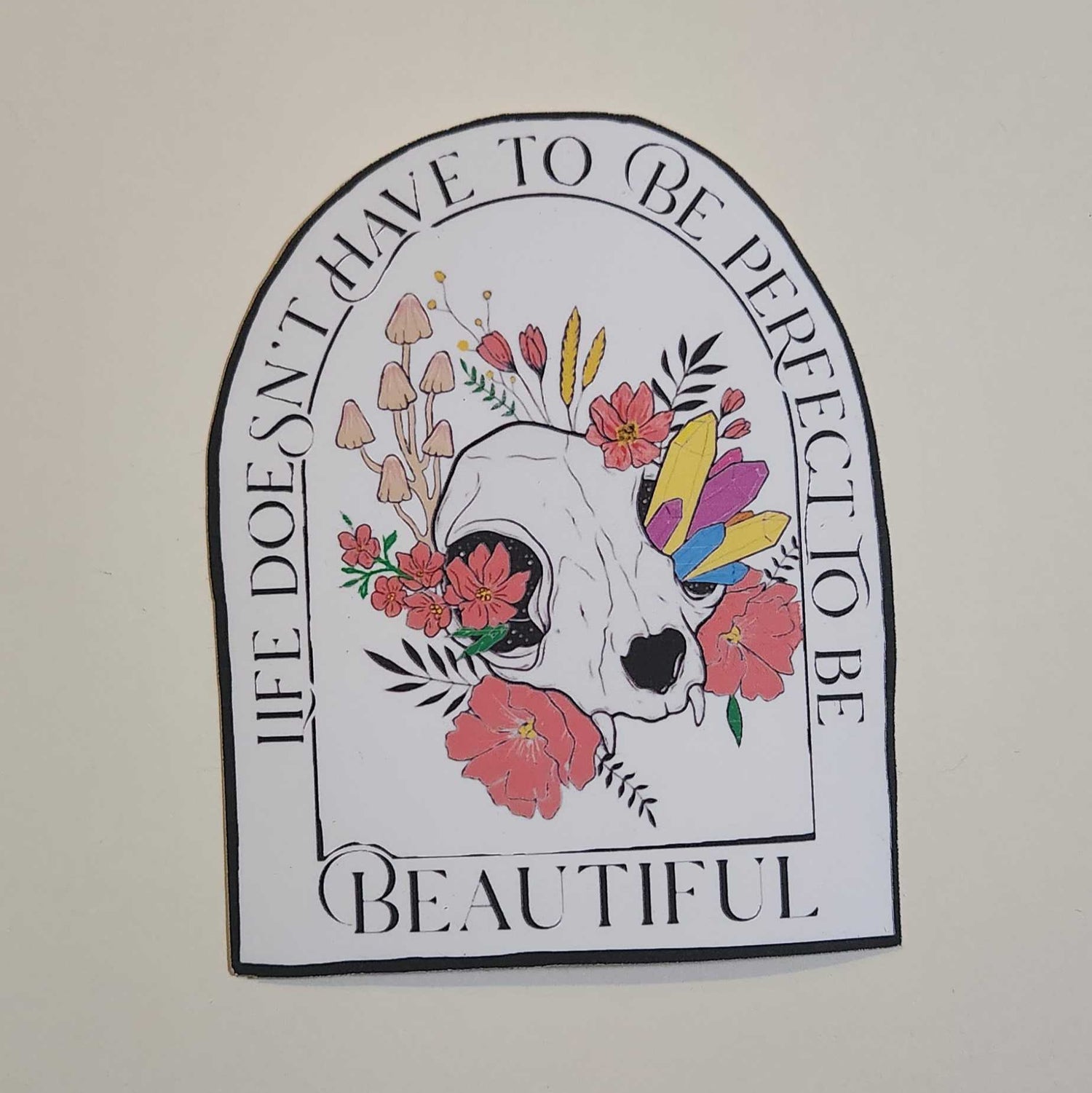 Decorative sticker with floral design and text on a plain background
