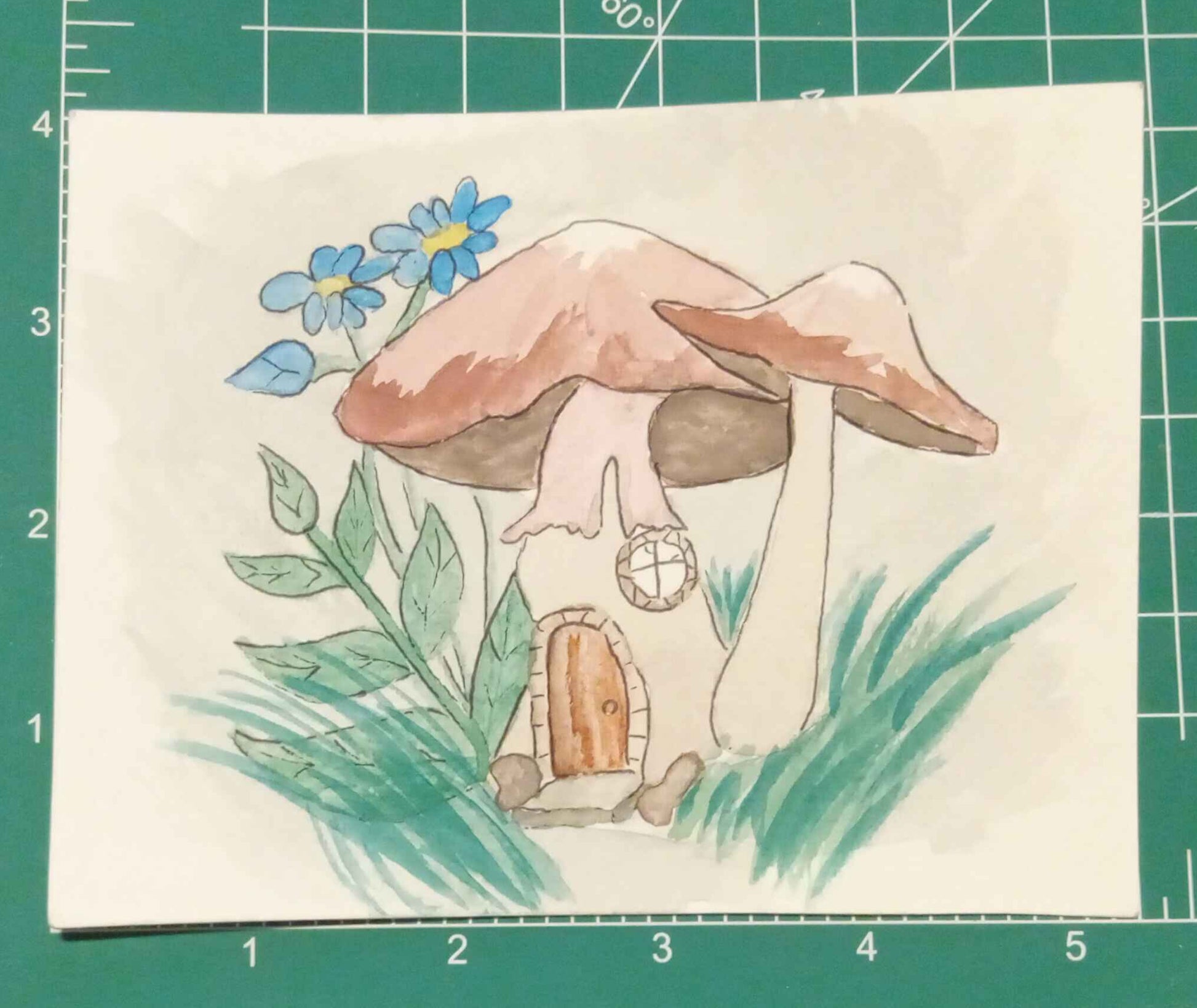Illustration of a mushroom house with flowers on a cutting mat