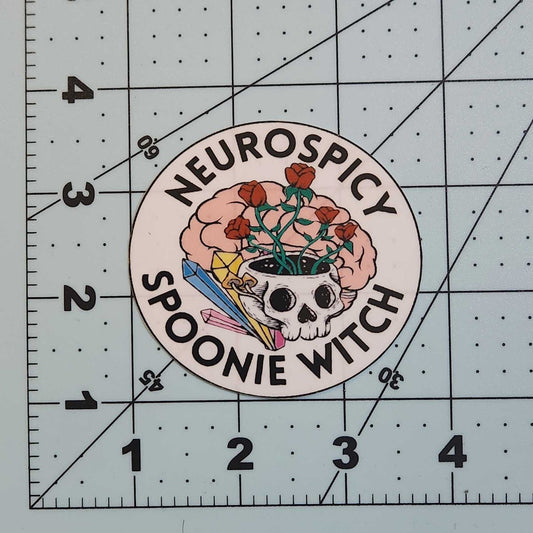 Circular sticker with text and graphics on a cutting mat with measurements.