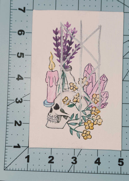 Illustration of a skull with flowers and candles on a cutting mat with ruler