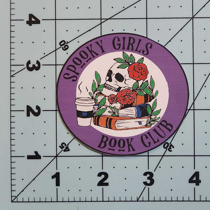 Circular patch with text and graphics on a cutting mat with measurements.