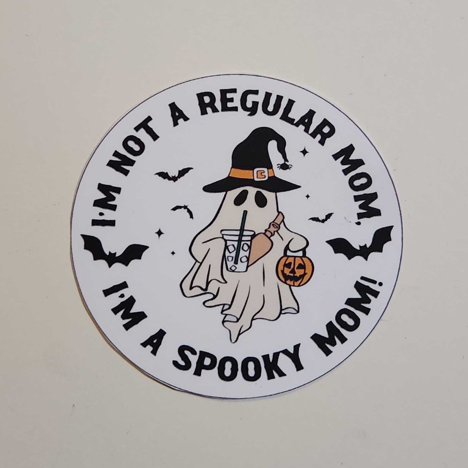 Circular sticker with Halloween-themed text and graphics on a white background